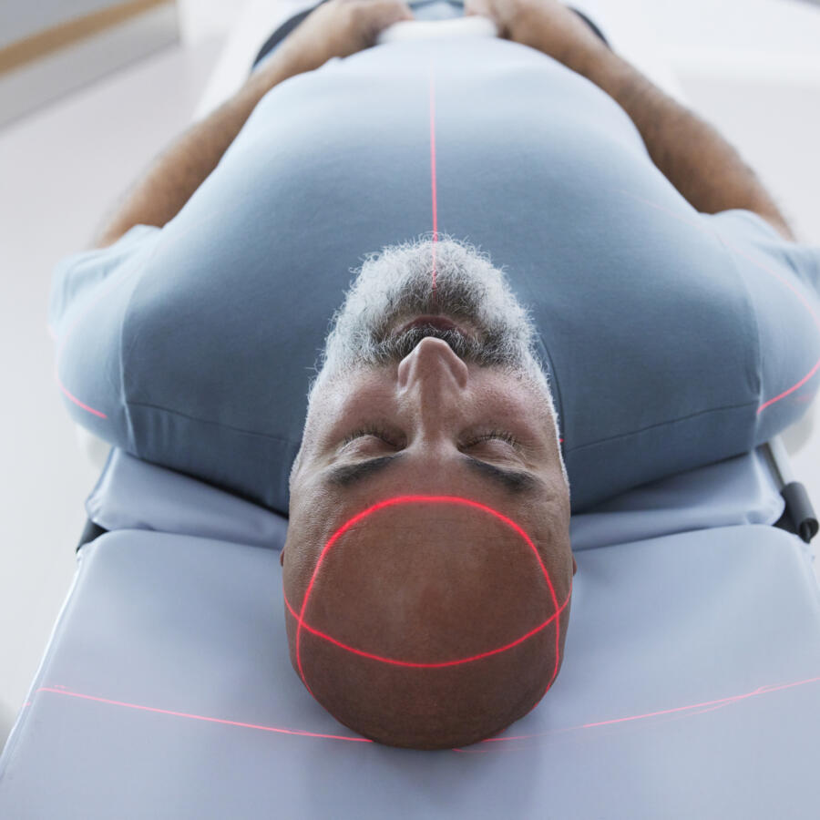 Man lying down with eyes closed inside a medical scanner