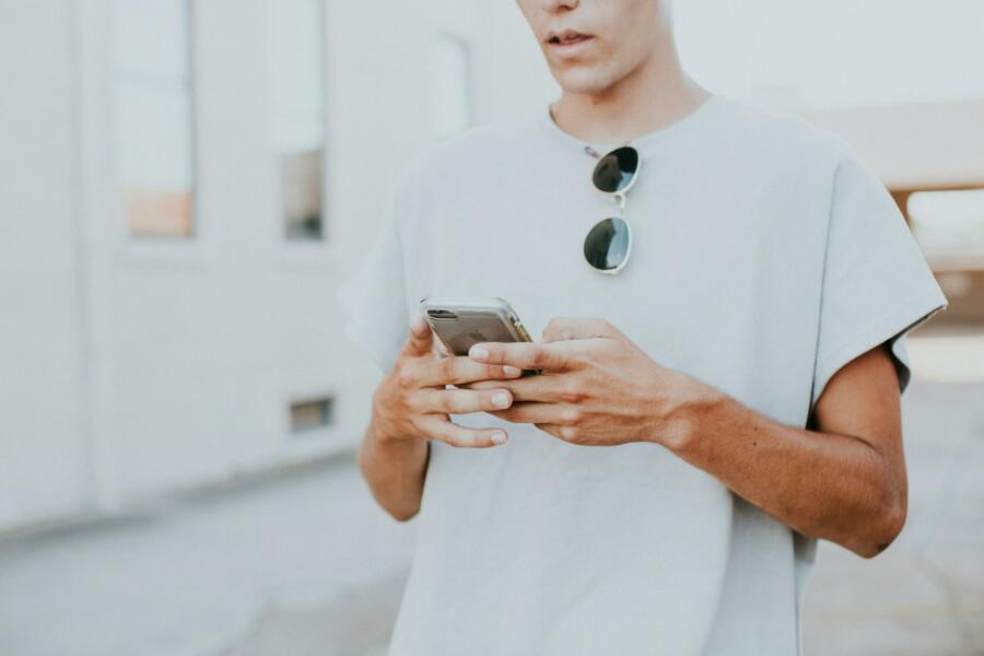 Man looking down at the iPhone he is holding in his hands