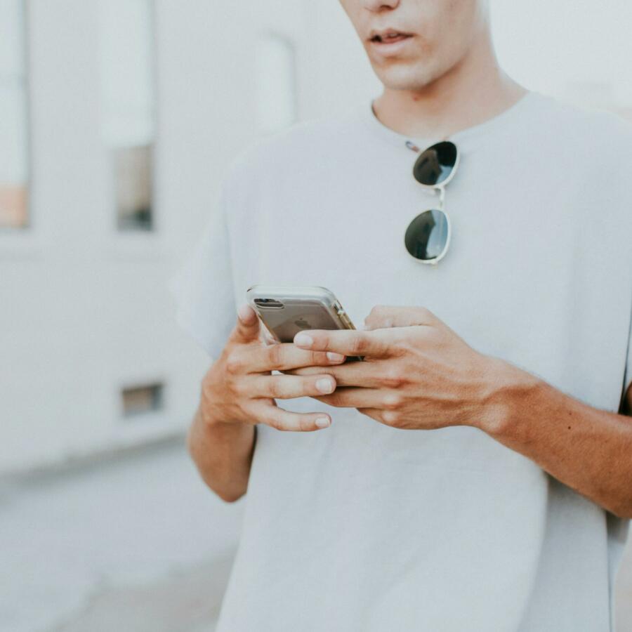 Man looking down at the iPhone he is holding in his hands