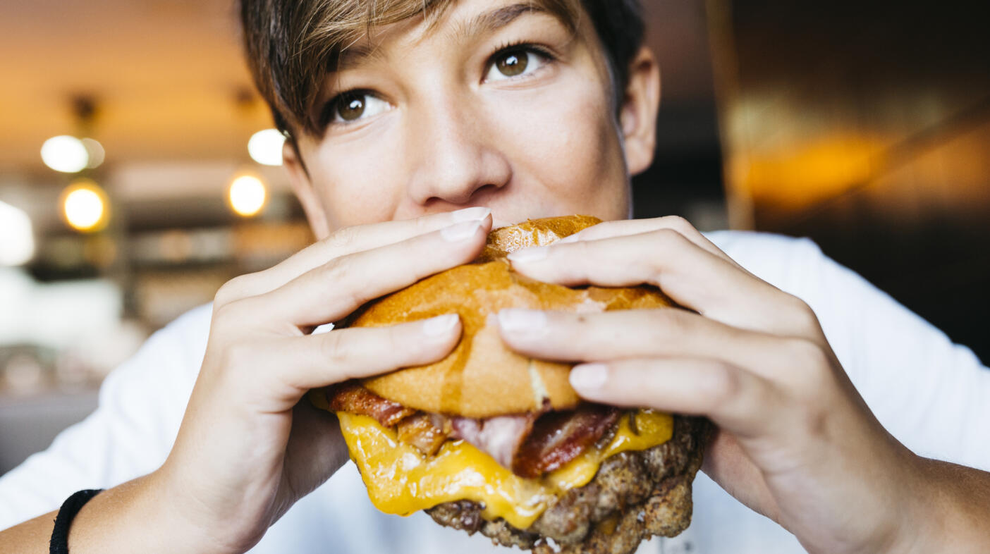 Teenager eating a burger