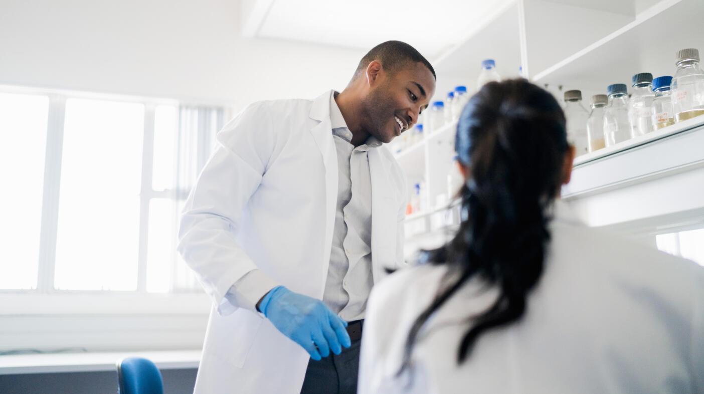 Smiling chemist with colleague at laboratory